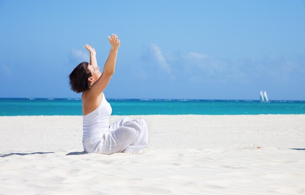 meditazione di donna felice nella posa del loto sulla spiaggia