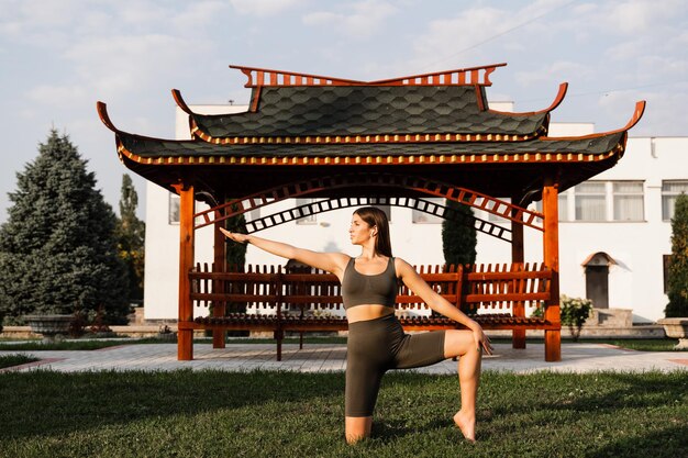 Meditazione e relax all'aperto La ragazza dell'abete asiatico sta meditando vicino al gazebo cinese