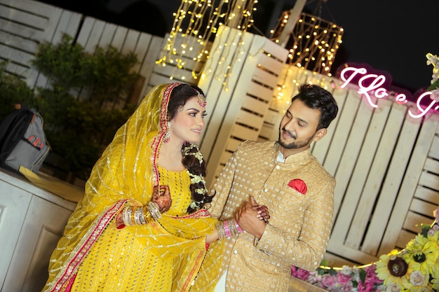 mehndi notte Coppia matrimonio sfondo giallo Sposa indiana o pakistana che mostra le mani mehndi design