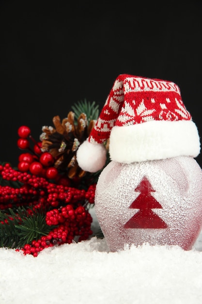 Mela delle vacanze con albero di Natale smerigliato nella neve su sfondo nero