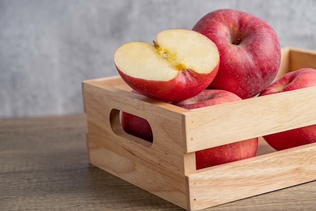 Mela e mezza frutta in scatola di legno con copia spazio.