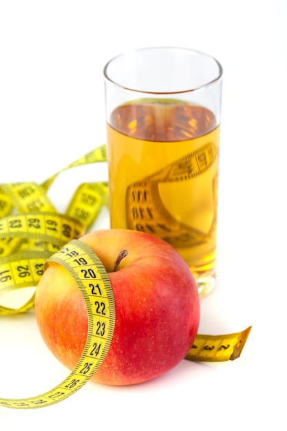 Mela e succo di mela con metro a nastro su sfondo bianco, cibo salutare