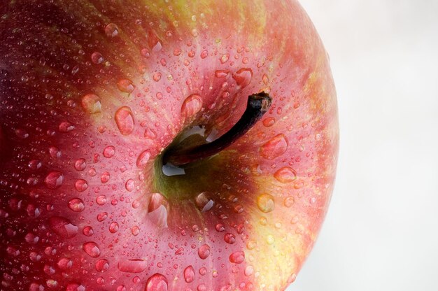 Mela rossa con gocce d'acqua macrofotografia ravvicinata di cibo vegetariano