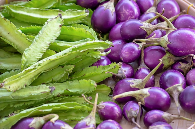 Melanzana e fagiolo alato viola, verdure in canestri di bambù.