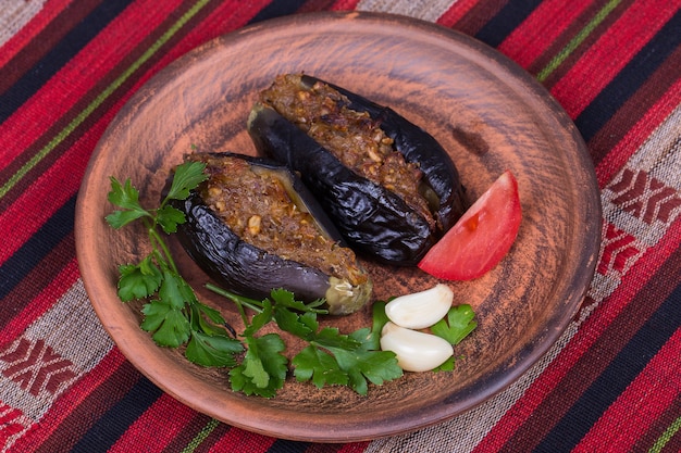 Melanzane al forno ripiene di cipolle, prugne ciliegie e noci sul piatto da vicino