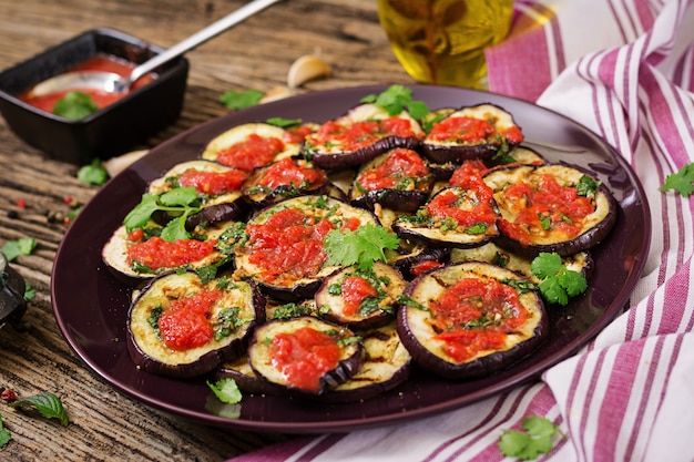 Melanzane grigliate con salsa di pomodoro, aglio, coriandolo e menta. Cibo vegano Melanzane grigliate