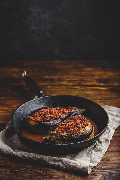 Melanzane ripiene di carne macinata pomodori e spezie in padella Piatto tradizionale Karniyarik della cucina turca