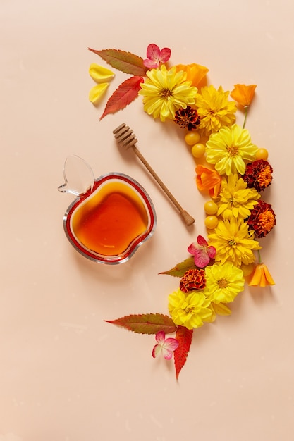 Mele, dalia, calendule, fiori di rudbeckia e miele. Concetto per Rosh Hashanah il capodanno ebraico. Vista dall'alto, primo piano, copia spazio su sfondo tono pastello.