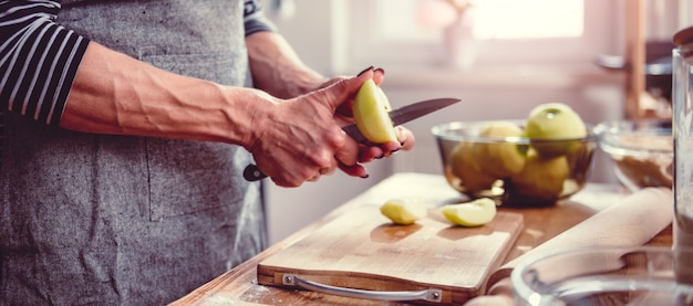 Mele di taglio della donna nella cucina