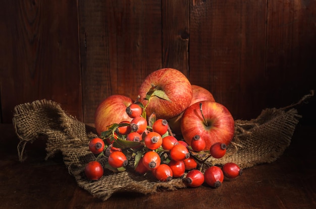 mele e altri frutti su uno sfondo di legno scuro in stile rustico