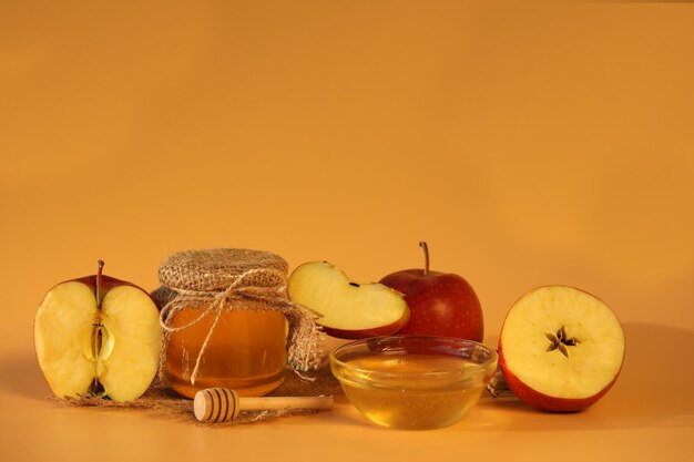 Mele fresche rosse con miele su sfondo giallo con spazio di copia. Festa delle mele