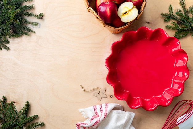 Mele fresche rosse e uno stampo in ceramica per fare la torta di mele fatta in casa per Natale e Capodanno Spazio di copia
