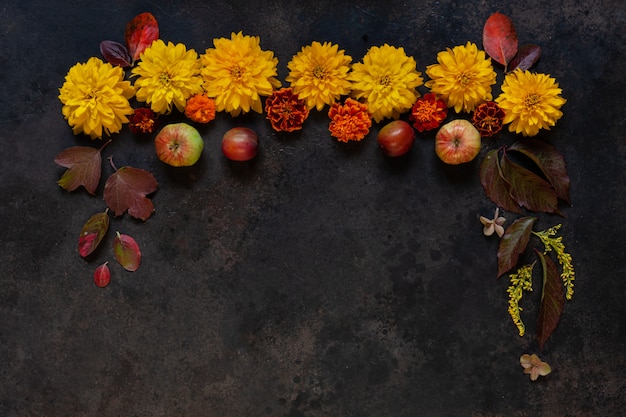 Mele, prugne selvatiche, bacche rosse e bellissimi fiori autunnali con decorazione floreale spazio copia.