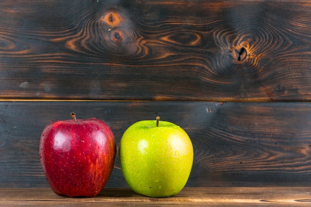 Mele rosse e verdi succose mature sulla tavola di legno rustica