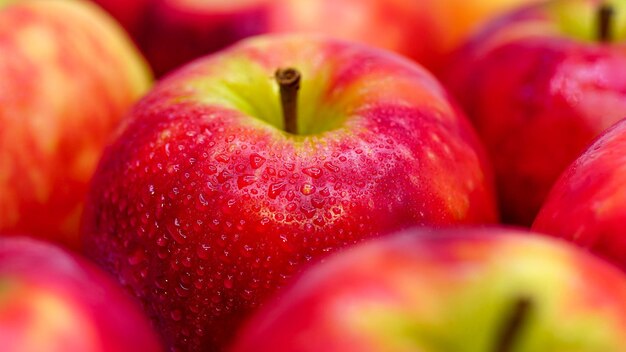 Mele rosse fresche con il primo piano delle gocce d'acqua