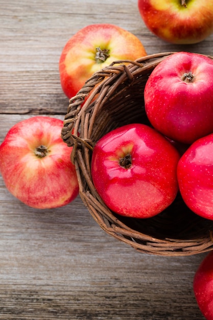 Mele rosse mature su fondo in legno.