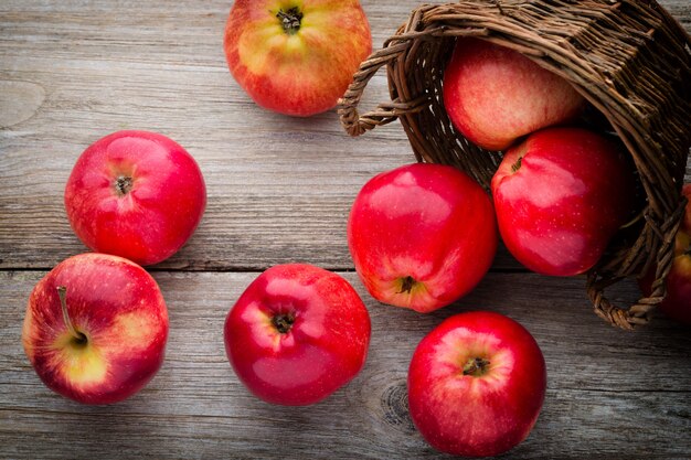 Mele rosse mature sulla tavola di legno.