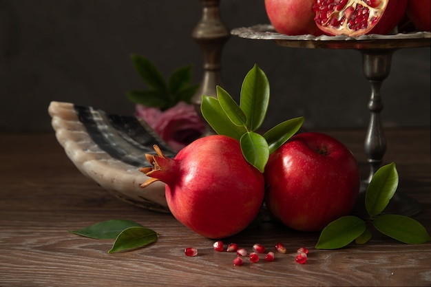 Mele rosse, shofar (corno) e melograni su un tavolo di legno, il concetto del nuovo anno ebraico - Rosh Hashanah.