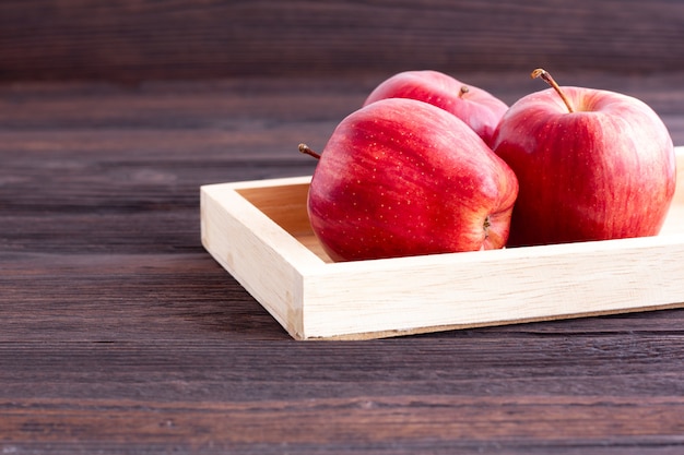 Mele rosse sul tavolo di legno.