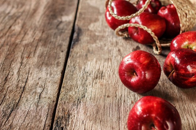 Mele rosse sul vecchio tavolo di legno