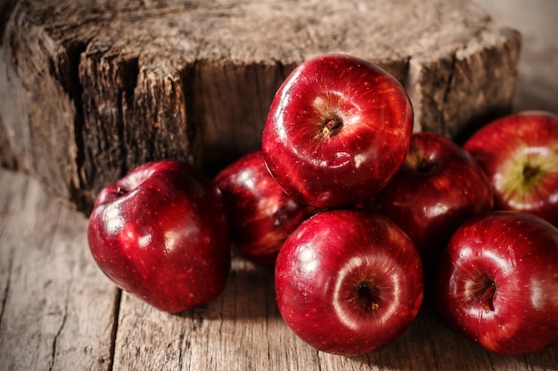 Mele rosse sul vecchio tavolo di legno