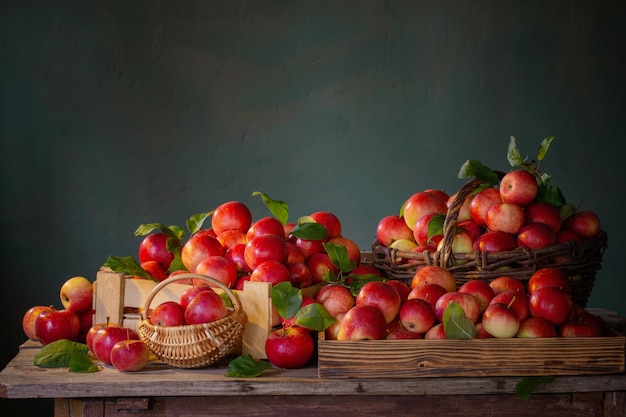 Mele rosse sulla vecchia tavola di legno sulla parete verde del fondo