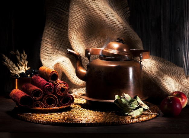 Mele secche ancora dolci e bollitore in rame vintage con tè in stile rustico