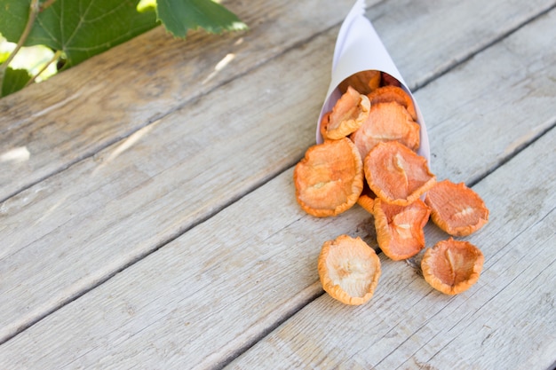 Mele secche, patatine fritte naturali su un legno