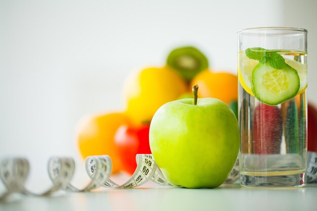 Mele verdi bicchiere d'acqua con foglie di menta limone e cetriolo misura di nastro concetto di mangiare sano