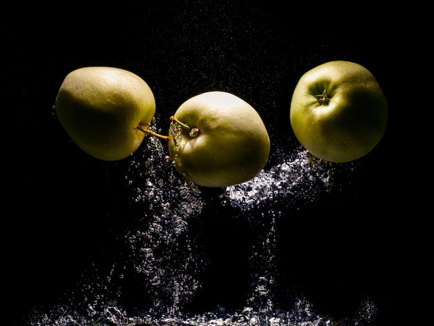 Mele verdi che cadono in acqua