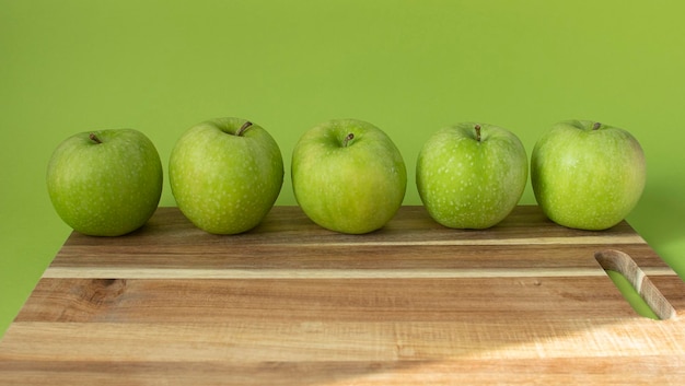 Mele verdi e fresche su fondo di legno e su colore verde