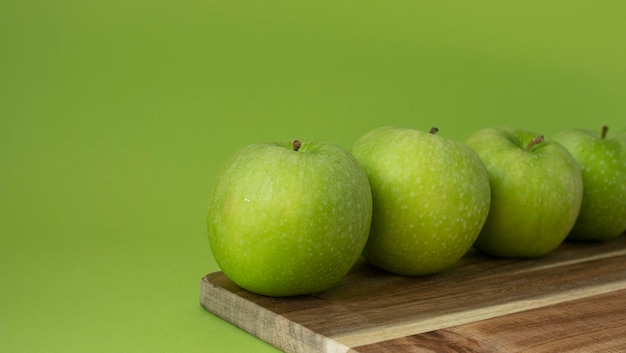 Mele verdi e fresche su fondo di legno e su colore verde