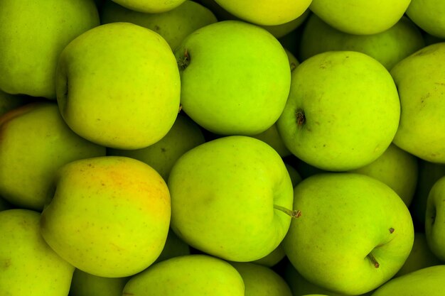 Mele verdi fresche che si trovano nel mucchio sul fondo dell'alimento mangiare sano dieta