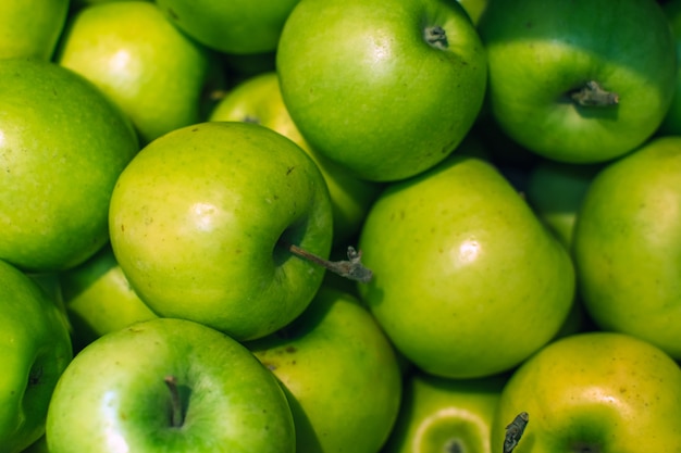 Mele verdi sfondo pieno di arance. Mela verde fresca sul mercato.