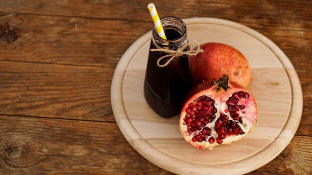 Melograni maturi con succo su fondo di legno