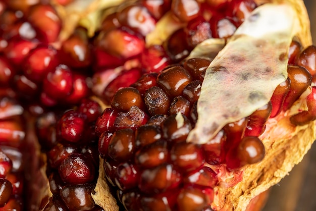 Melograno maturo rosso rovinato marcio sul tavolo frutto di melograno viziato e pericoloso per la salute