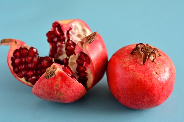 melograno rosso con grani isolati su sfondo blu, macro