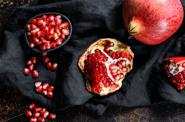 Melograno rosso maturo. Frutta biologica. Sfondo nero. Vista dall'alto.