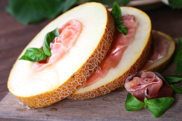 Melone con prosciutto di Parma sul primo piano della tavola di legno