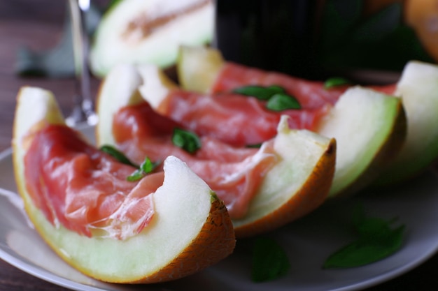 Melone con prosciutto di Parma sul primo piano della tavola di legno