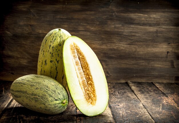 Melone fresco maturo su uno sfondo di legno