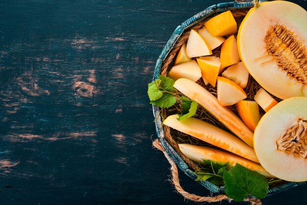 Melone in una scatola di legno Tagliato a pezzi di melone Su uno sfondo di legno Spazio libero per il testo Vista dall'alto