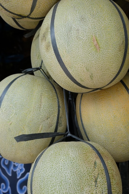 Meloni freschi legati su una corda al melone della bancarella della frutta