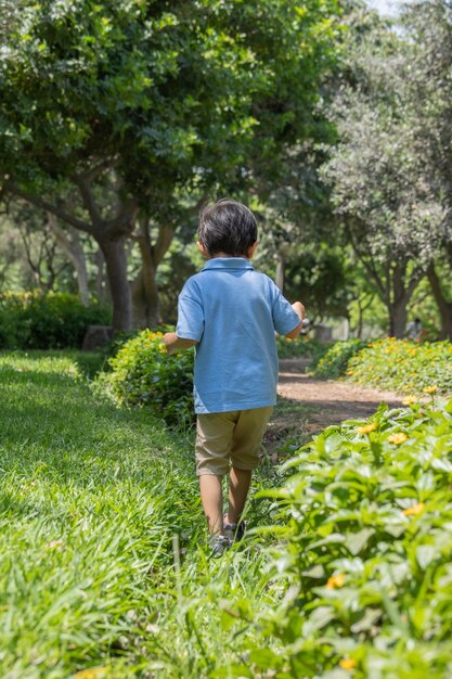 Membri della famiglia che si tengono per mano e camminano all'indietro in un parco insieme