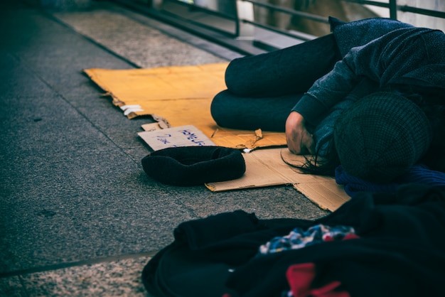 Mendicanti, senzatetto distesi sul pavimento su un cavalcavia.