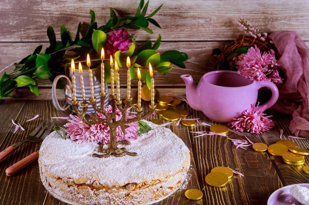 Menorah con candele accese sulla cima della torta festiva