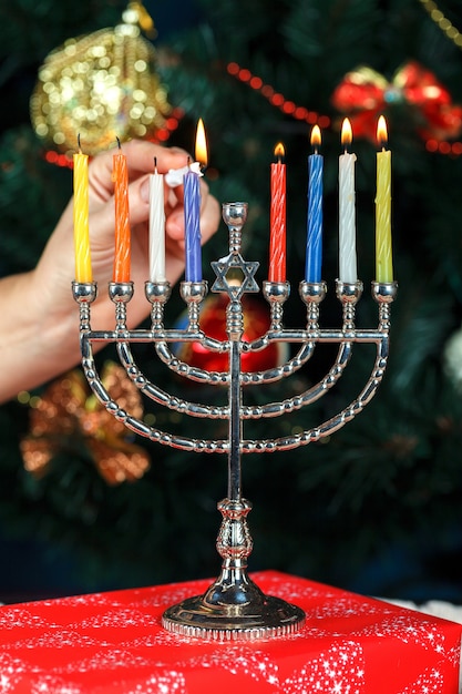 Menorah con candele per Hanukka sullo sfondo dell&#39;albero di Capodanno