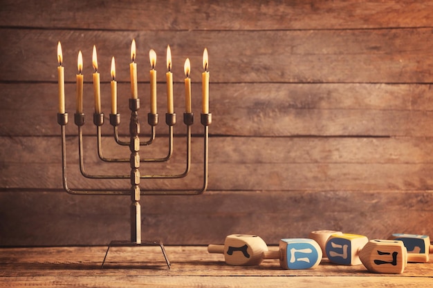 Menorah con candele per Hanukkah sul tavolo su sfondo di legno