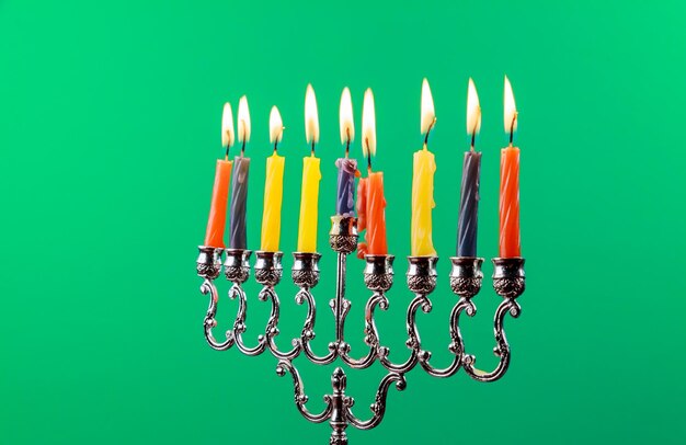 Menorah di Hanukkah con candele Candele di Hanukkah felice che brucia l'isolamento dello sfondo verde