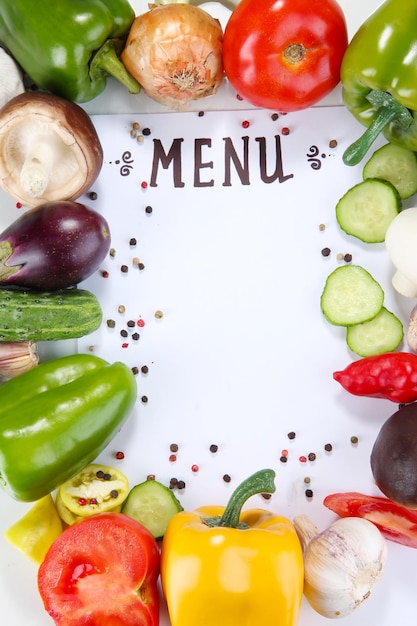 Menu circondato da prodotti e verdure isolate su bianco